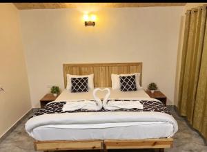 a bedroom with a large bed with a wooden headboard at Rivanta Resort Kasol in Kasol