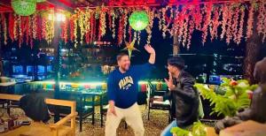 two men are standing in a room with lights at Rivanta Resort Kasol in Kasol