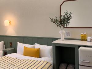 a bedroom with a bed and a vase with flowers in it at Casa olive 까사올리브 in Millak-tong