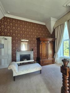 a living room with a fireplace and a chair at Glenduff Manor in Glendiff