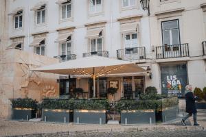 a person walking past a building with an umbrella at AlmaLusa Baixa/Chiado in Lisbon