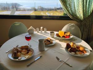 a table with two plates of food and glasses of wine at Hotel Agnanti Unique Hospitality in Kastoria