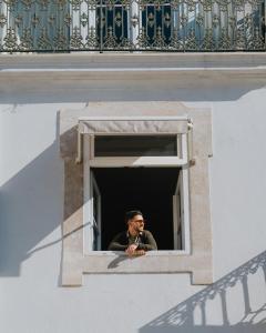 a man is looking out of a window at AlmaLusa Baixa/Chiado in Lisbon