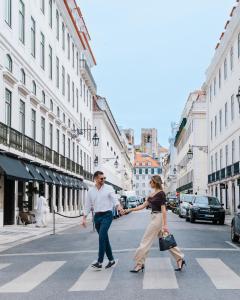 a man and woman crossing a street on a crosswalk at AlmaLusa Baixa/Chiado in Lisbon +105 photos
