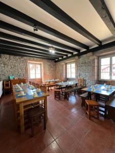 a dining room with tables and chairs and windows at Amaiurko Aterpetxea in Maya del Baztán