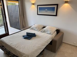 a bedroom with a bed with two blue robes on it at Superbe studio terrasse piscine et plage in Fréjus
