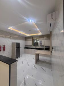 a large white kitchen with a table and appliances at درة القيم in Taif
