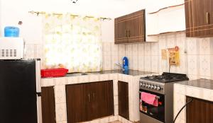 a kitchen with wooden cabinets and a stove top oven at Eldoville Home in Eldoret