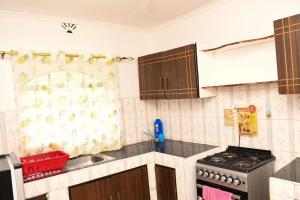 a kitchen with a sink and a stove at Eldoville Home in Eldoret