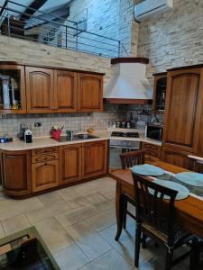 a kitchen with wooden cabinets and a wooden dining table at Appartamento Luigia House in Cornaredo