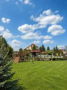 a yard with a playground and a house at Penzión Pulse in Podhájska