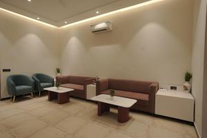 a waiting room with a couch and two tables at Damru in Jaipur