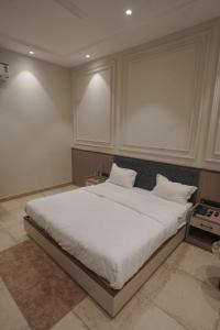 a bedroom with a large bed with white sheets at Damru in Jaipur