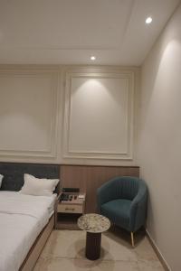 a bedroom with a bed and a blue chair at Damru in Jaipur