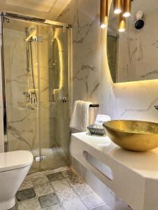 a bathroom with a sink and a shower with a bowl at HOTEL FUENTE REDONDA LUXURY in Úbeda +29 photos