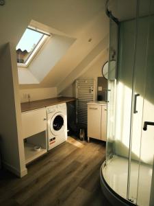 a laundry room with a washer and a window at l'imprimerie in Malestroit