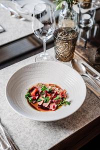 a plate of food on a table with a wine glass at Hotel Goldener Berg in Lech am Arlberg