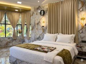 a bedroom with a large bed and a large window at Majestic Marvel in Maraiyūr