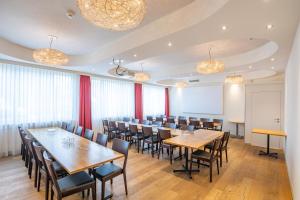 a dining room with wooden tables and chairs at Hotel Holiday Thun in Thun