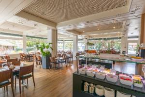a restaurant with wooden floors and tables and chairs at Hotel Holiday Thun in Thun