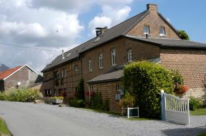 ein Backsteinhaus mit einem weißen Zaun neben einer Straße in der Unterkunft Appartement Hoeve Espewey - Leisure only in Hombourg