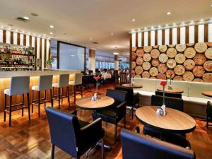 a restaurant with tables and chairs and a bar at Flat Vila Olimpia Hotel Experience in São Paulo