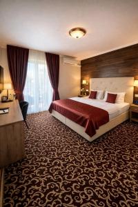 a hotel room with a large bed with red sheets at Penzión Pulse in Podhájska