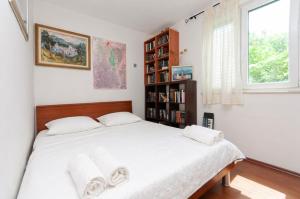 a bedroom with a bed and a book shelf at Holiday House Therapy in Omiš