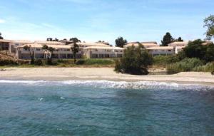 a view of a beach with buildings in the background at Magnifique T3 full équipé, 100m de la plage et piscine N60 in Linguizzetta