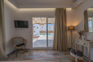 a living room with a sliding glass door to a patio at Depis luxury private villas in Plaka