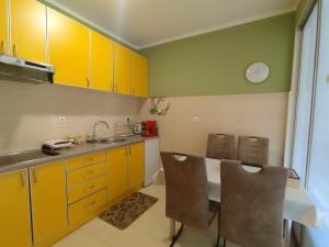 a kitchen with yellow cabinets and a sink at Apartment Temple in Podgorica
