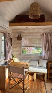 a room with a couch and a table and a window at Tiny chouette et jacuzzi in Doulezon