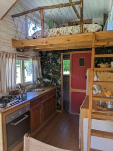 a kitchen in a tiny house with a loft at Tiny chouette et jacuzzi in Doulezon +18 photos