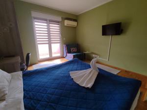 a bedroom with a blue bed and a window at Apartment Temple in Podgorica