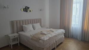 a bedroom with a large bed with a white bedspread at Vila BELVEDERE in Brăila