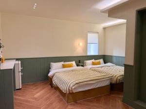 two beds in a room with green walls at Casa olive 까사올리브 in Millak-tong