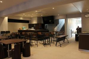 a restaurant with tables and chairs and a staircase at Art Five Hotel BOIS博多 in Fukuoka