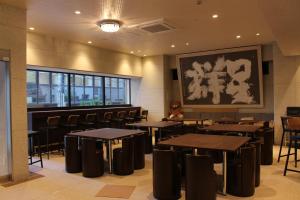 a restaurant with tables and chairs and a teddy bear at Art Five Hotel BOIS博多 in Fukuoka