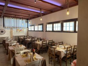 a dining room with tables and chairs and windows at Locanda Patoea Alloggi in Borgoricco