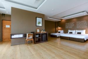 a hotel room with two beds and a desk at Brown House Hotel in Udon Thani +132 photos