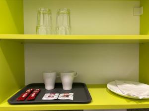 a tray with two glasses and a plate on a shelf at Tisza Garden Park in Tiszalök