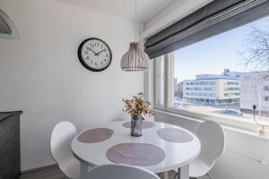 a dining room with a table and chairs and a clock at Nordic Nook By Elys Collection in Rovaniemi +17 photos