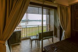 a bedroom with a large window with a view of a river at Brown House Hotel in Udon Thani