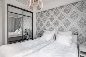 a bedroom with a large white bed and a mirror at Nordic Nook By Elys Collection in Rovaniemi