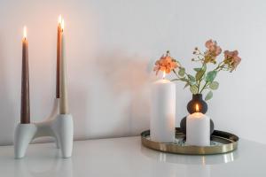two candles and a vase with flowers on a table at Nordic Nook By Elys Collection in Rovaniemi
