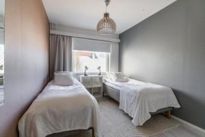two beds in a room with a window at Nordic Nook By Elys Collection in Rovaniemi