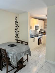 a dining room with a table and a kitchen at Castell Cottages Central with Parking in Caerphilly