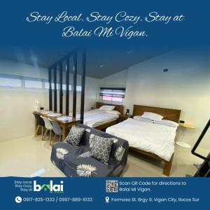 a bedroom with a bed and a table and a chair at Balai Mi Vigan in Vigan +2 photos
