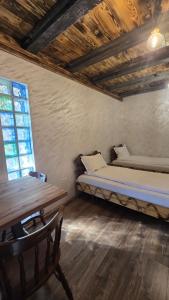 a bedroom with a bed and a table and a window at La Hotar in Buchin
