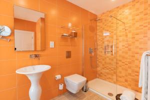 a bathroom with a toilet and a sink and a shower at Quaint Boutique Hotel Sannat in Sannat +26 photos